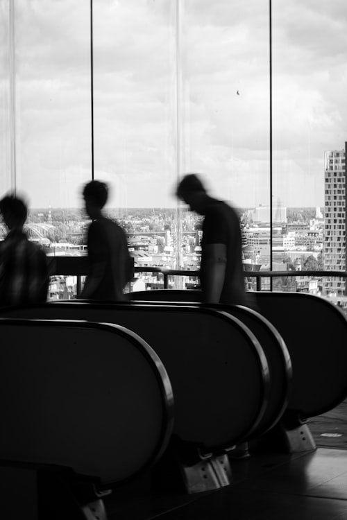 People leaving a building, going down an escalator